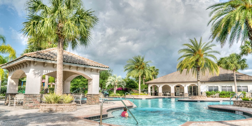 A family enjoys swimming in a water park surrounded by palm trees—a perfect getaway