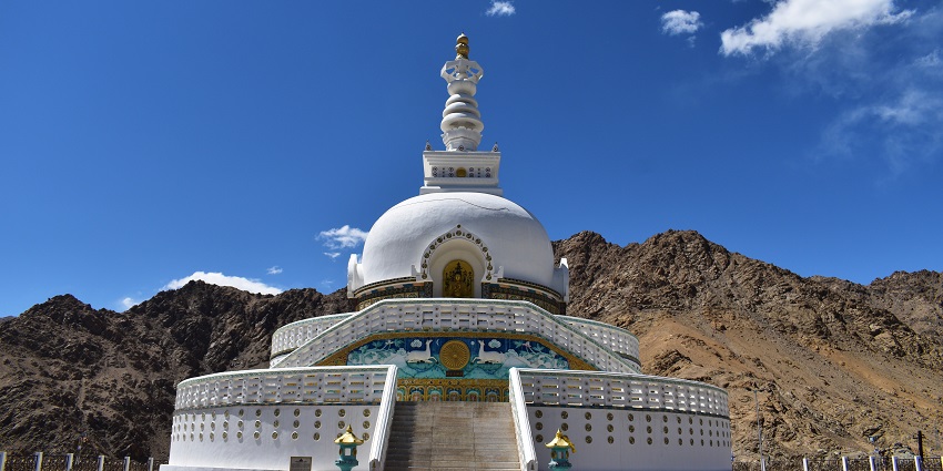 Wide angle view of the Shanti stupa with bright blue sky in the background