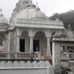 A Jain temple built with white marble is situated in a large area amidst greenery