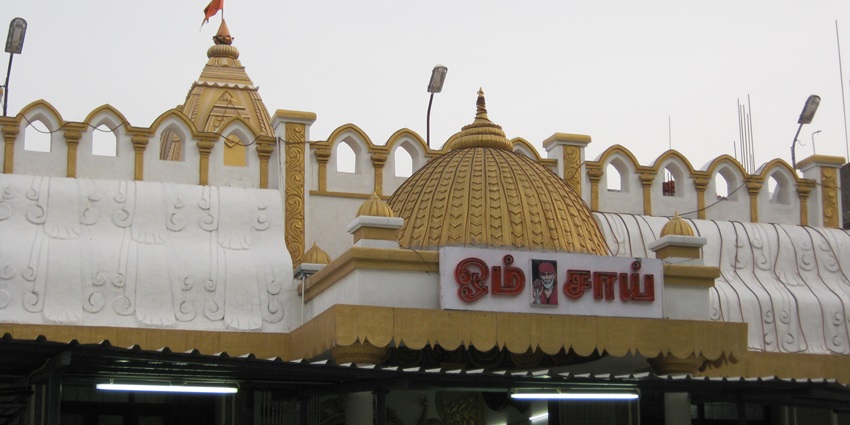 A picture of the entrance of a temple premises with white and yellow paint