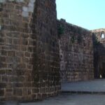 Shirgaon Fort with its sturdy stone walls and watchtowers, set against a backdrop of clear skies