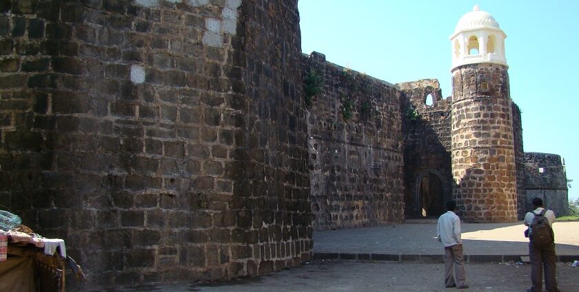 Shirgaon Fort with its sturdy stone walls and watchtowers, set against a backdrop of clear skies