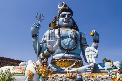 Shiva idol at Koneswaram Temple, overlooking the ocean, surrounded by rich greenery.