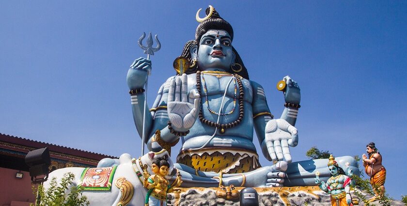 Shiva idol at Koneswaram Temple, overlooking the ocean, surrounded by rich greenery.