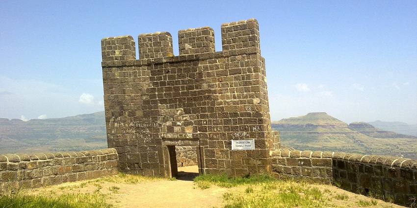 A fortified gateway with surrounding hills, popular destination near Lenyadri Caves.