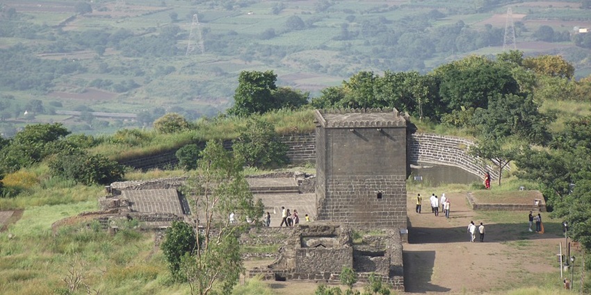 Scenic view of Shivneri Fort, surrounded by lush greenery and mountains.