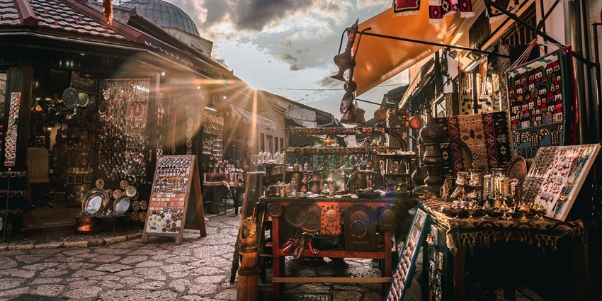 A picture of a bustling market with multiple shops, taken on a sunny day