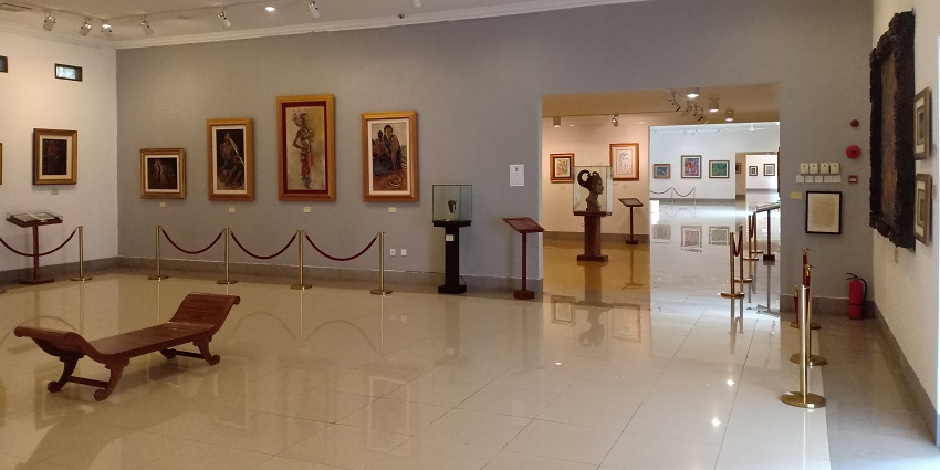 An art gallery with several paintings and art works displayed.