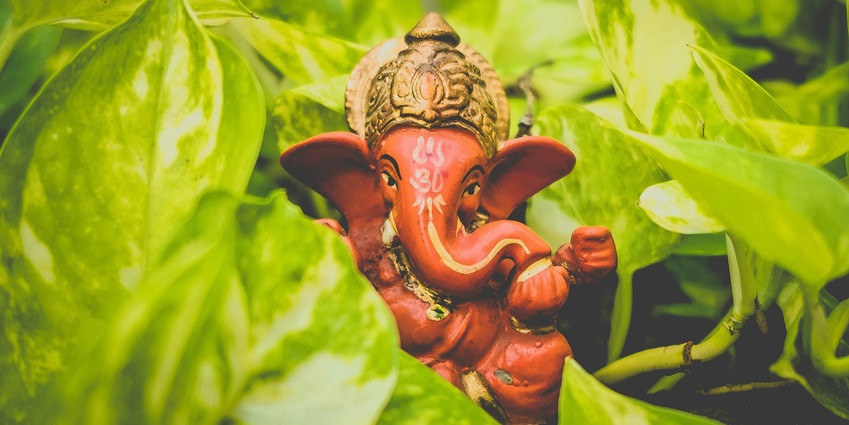 Image of a Ganesh idol around money plants decorated - one of the best places to visit in mumbai in summer