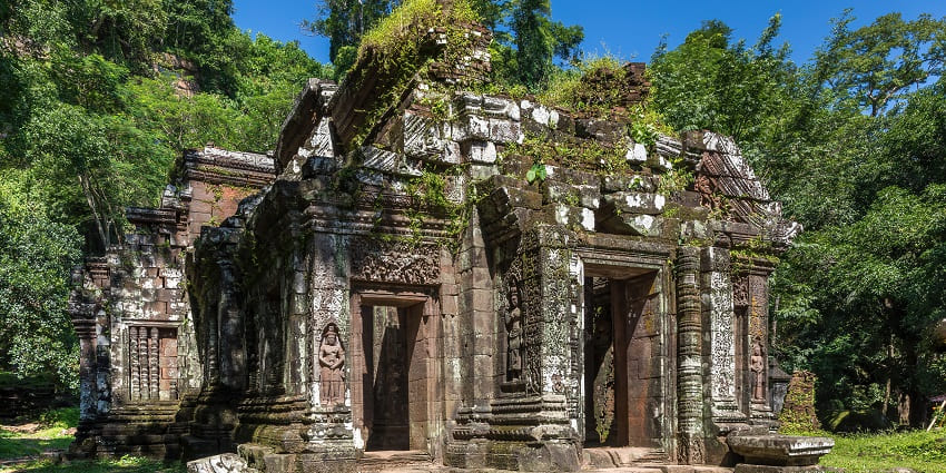 A picture of the exterior view of a temple with trees and greenery in the surroundings
