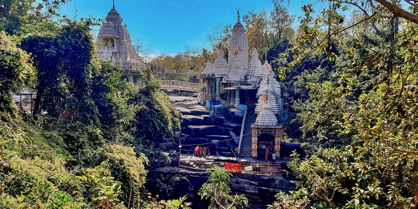 A beautiful view of the Shri Jatmai Temple on a hillside surrounded by lush greenery
