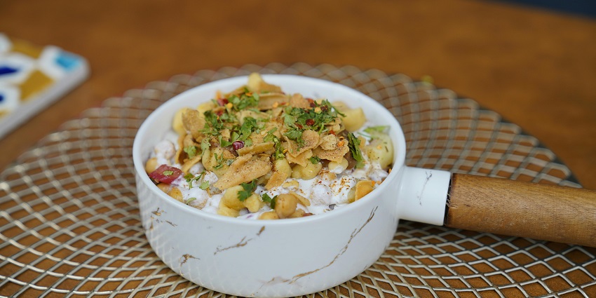 Dahi Bhalla served in a bowl topped with sev, coriander leaves, and pomegranate seeds