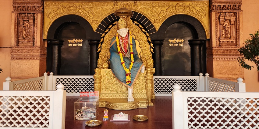 An amazing view of idol of Sai Baba adorned with beautiful clothes and vibrant flowers.