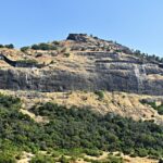 Majestic view of Shrivardhan Fort atop a hill surrounded by lush greenery