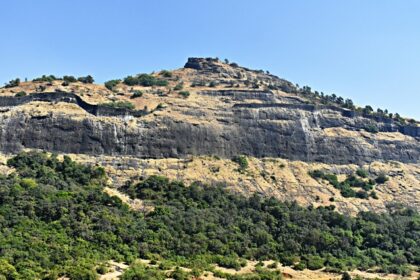 Majestic view of Shrivardhan Fort atop a hill surrounded by lush greenery