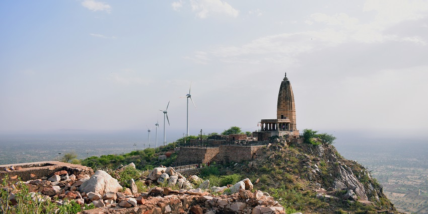 Hills of Sikar with Harshnath temple at a distance with visible windmills and rocky land.