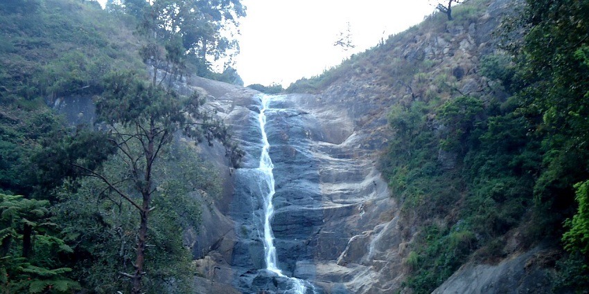 Water falling against the rugged rocks at Silver Cascade Falls in Kodaikanal