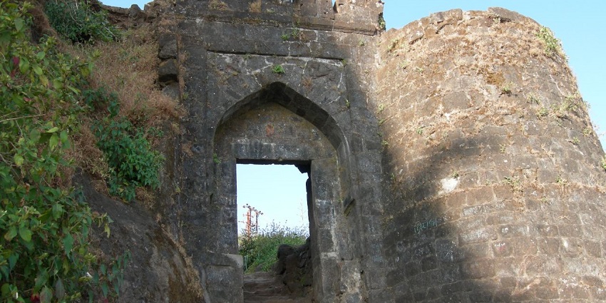 An entrance gate of the historic Sinhagad Fort is made up of stone and has stone steps