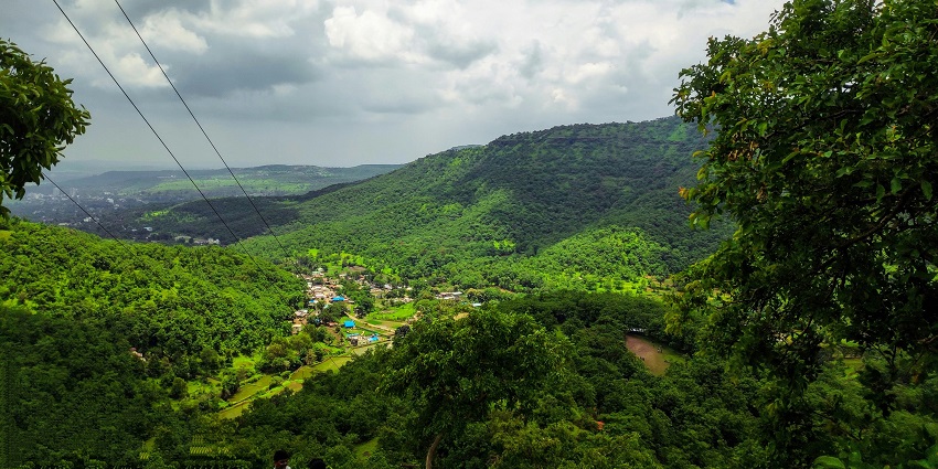 Panoramic stunning view of Sinhagad Fort, atop a hill, surrounded by lush valleys.