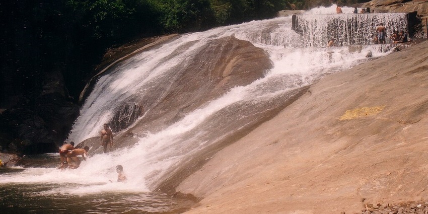 Tourist swimming at the dip of the waterfall near the Marudhamalai Temple.