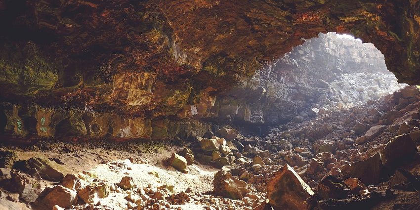 An inside view of the majestic Sita Gumpha featuring sculptured walls and big rocks.