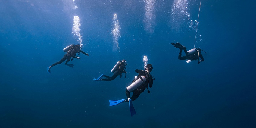 Scuba divers on Bingin Beach exploring numerous underwater reefs and appreciating biodiversity.