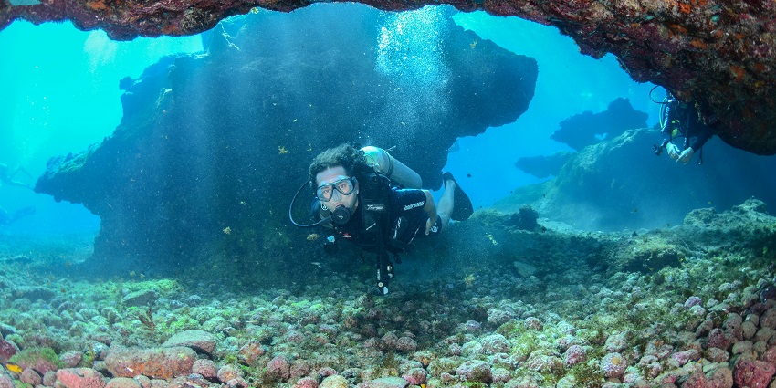 A man scuba diving near a vibrant coral reef, exploring the underwater world filled with marine life