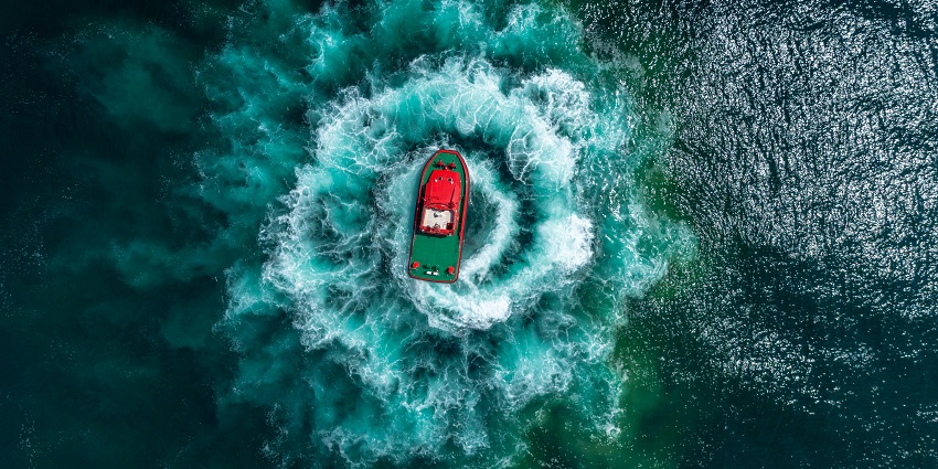 A scenic picture of a speedboat racing across the waves near Mandwa Beach.