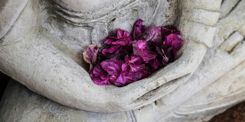 A close-up of a concrete statuette, highlighting its textured surface and design details.