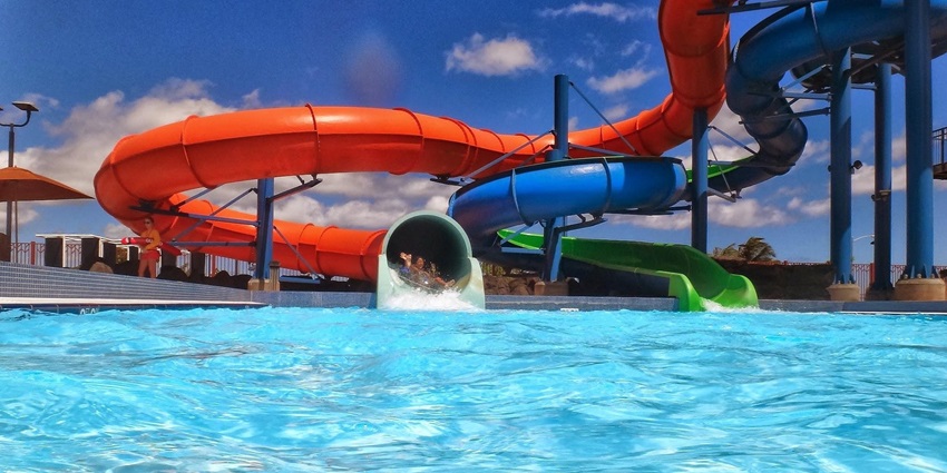 Image of waterslides around the pool with colourful slides in orange, blue and green