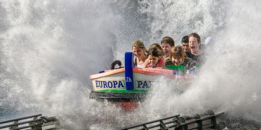 A group of people enjoying a boat ride in a Shirdi water park under a bright sky.