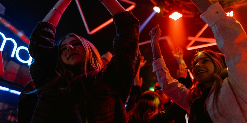 Vibrant discotheque scene with people dancing, enjoying fun music and lively atmosphere.