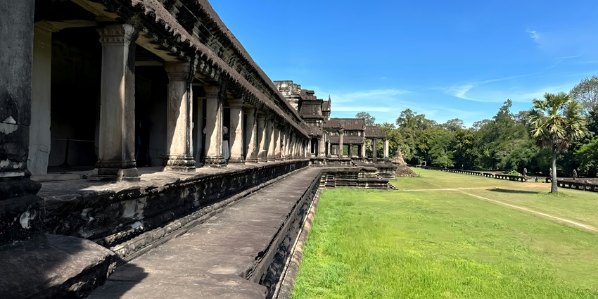 People walking up and down stairs near a large temple with intricate architecture