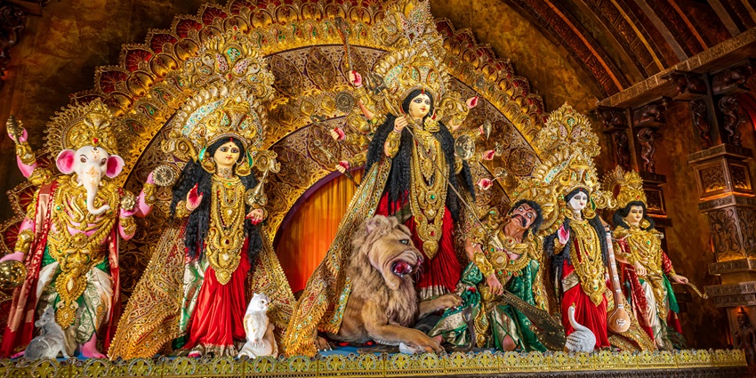 Intricate display of Durga Puja idols with various deities, showcasing vibrant colours and details