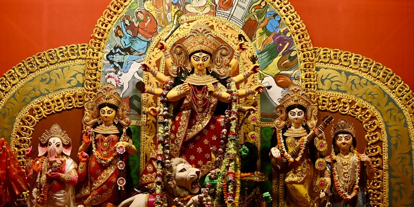Golden Hindu altar adorned with intricate carvings and vibrant decorations for worship.