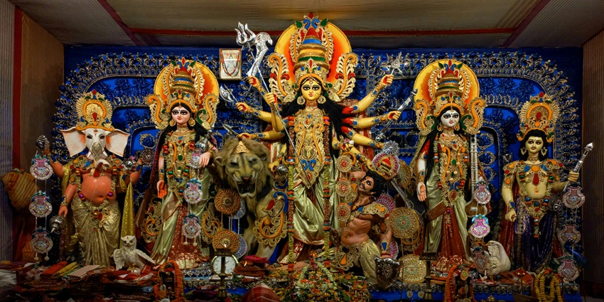 Figurines of Hindu deities arranged on a colourful altar, highlighting their intricate details