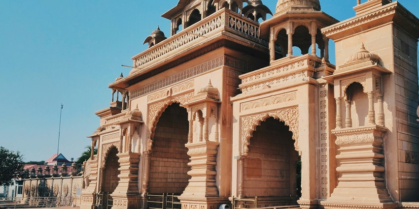 Temple arcade with tall pillars and intricate carvings, creating a majestic walkway