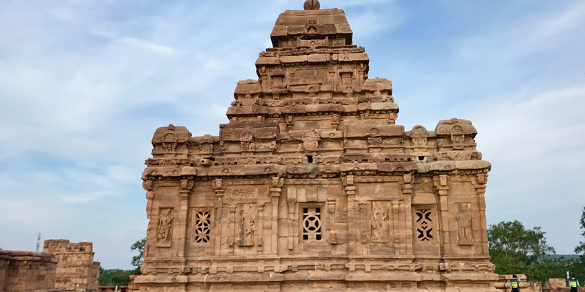 Image of the Sri Parswanath Jain Temple surrounded by greenery and with blue sky in background