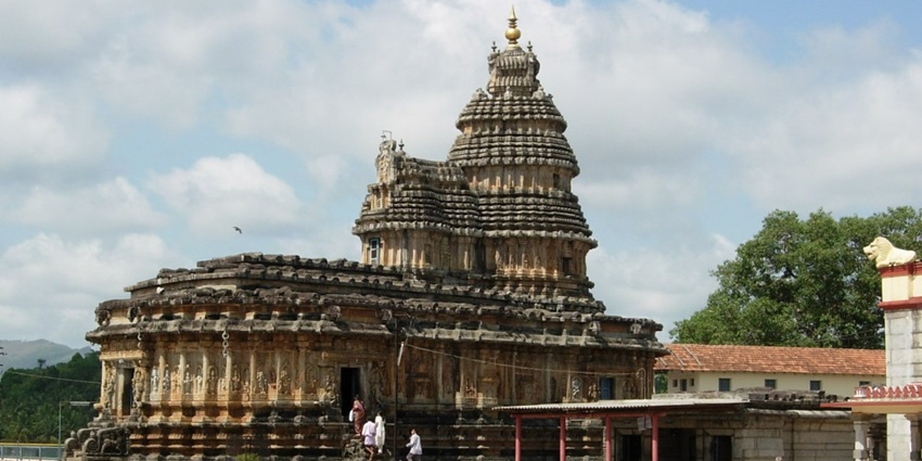 A picture of an ancient temple taken from a distance, built using traditional Hindu architecture