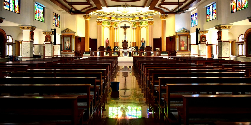 Interior of a large church with wooden pews, a notable place to visit in Virar