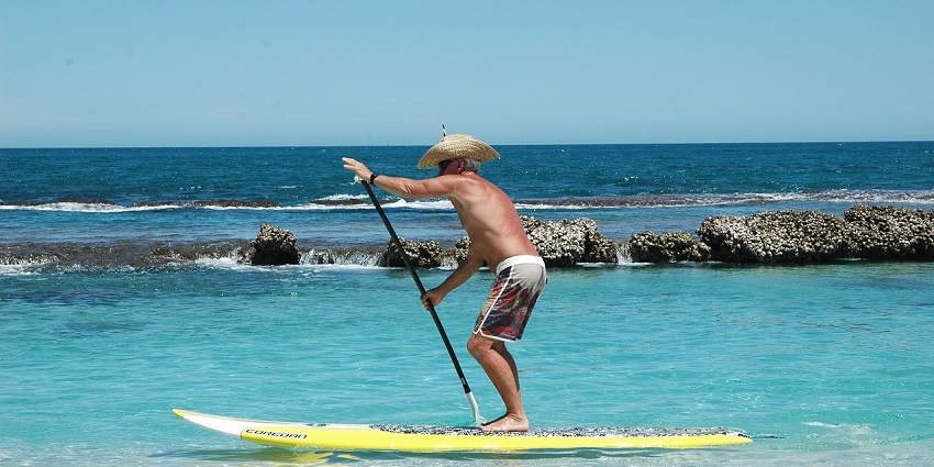 A picture of a person
enjoying paddleboarding in the calm waters of Murud Beach, Dapoli.