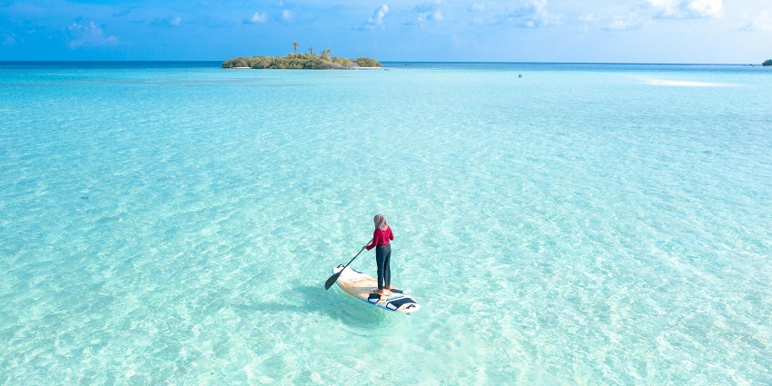 A picture of a person paddle boarding in the still waters of Chivla Beach.