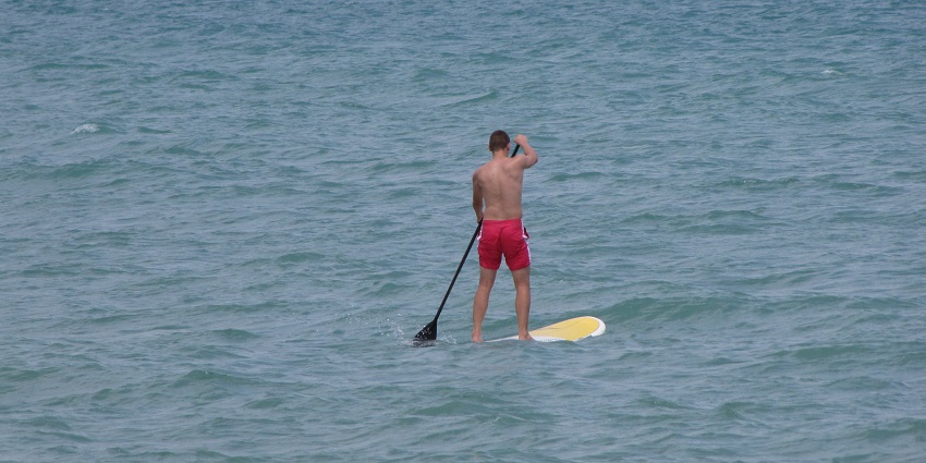 A picture of stand-up paddleboarding, a trendy activity in water sports in Alibaug.