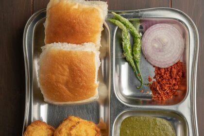 Glass jars filled with different items and man cutting tomato for bhelpuri preparation