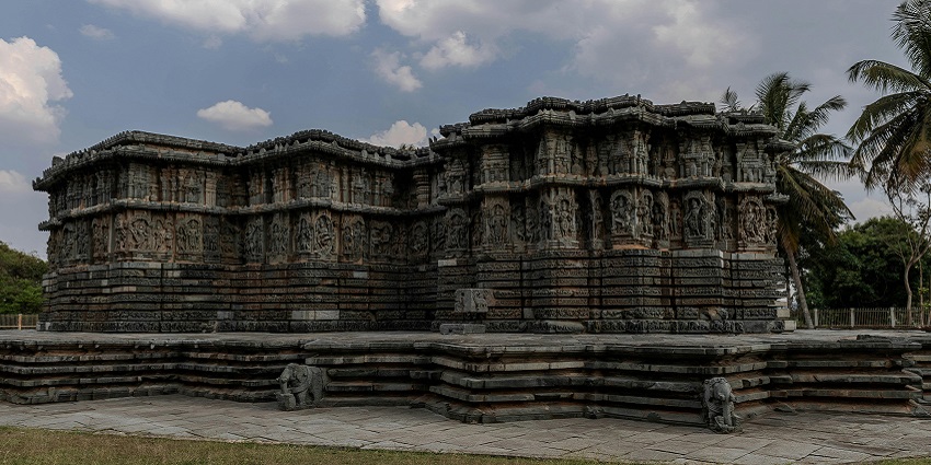 An image of an ancient stone temple with intricate carvings on its pillars and walls.