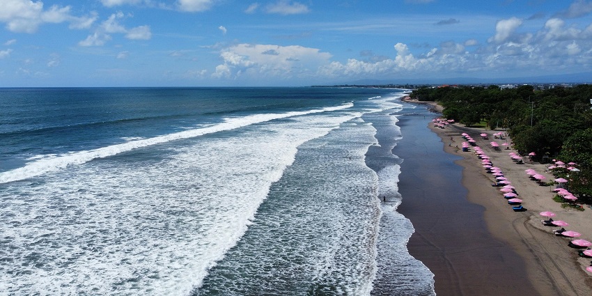 Aerial view of sea waves crashing onto the shore of Suluban Beach