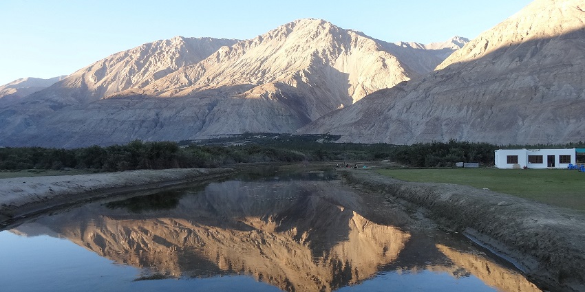 Beautiful landscape of Sumur Village, featuring mountains and lush greenery.