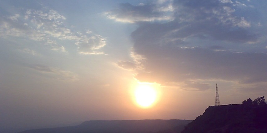 Serene sunrise over lush Panhala hills, bathed in golden glow