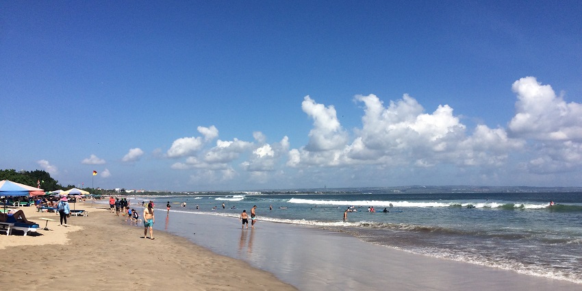 People playing and chilling at the Double Six beach in Kuta on the island of Bali.