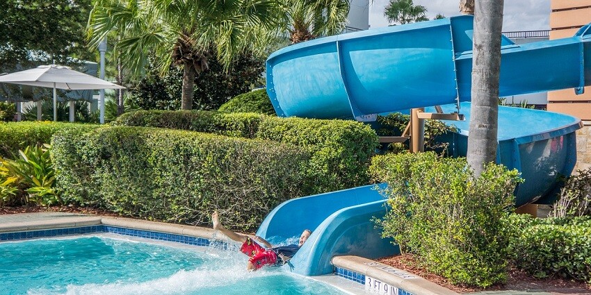 A photo of a child enjoying a water slide at an amusement park in Thane on a sunny day.